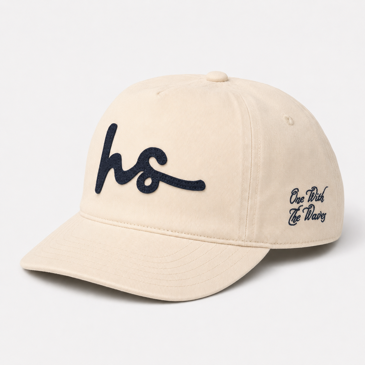 A beige baseball cap with dark navy blue embroidered script on the front and side, shown on a clean white background.